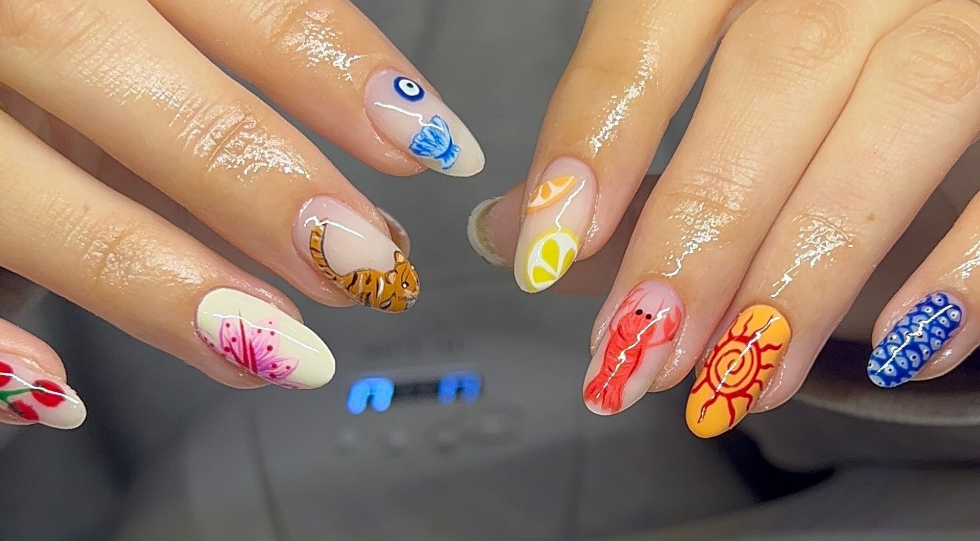 Colorful hand-painted nail art with fruit and animal motifs